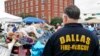A Dallas firefighter pays respects at the makeshift memorial for fallen officers outside Dallas police headquarters in Texas, July 11, 2016. (M. O'Sullivan/VOA)