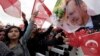 Supporters wave flags as Turkey's President Recep Tayyip Erdogan delivers a speech during a rally of supporters a day after the referendum, at his palace, in Ankara, April 17, 20