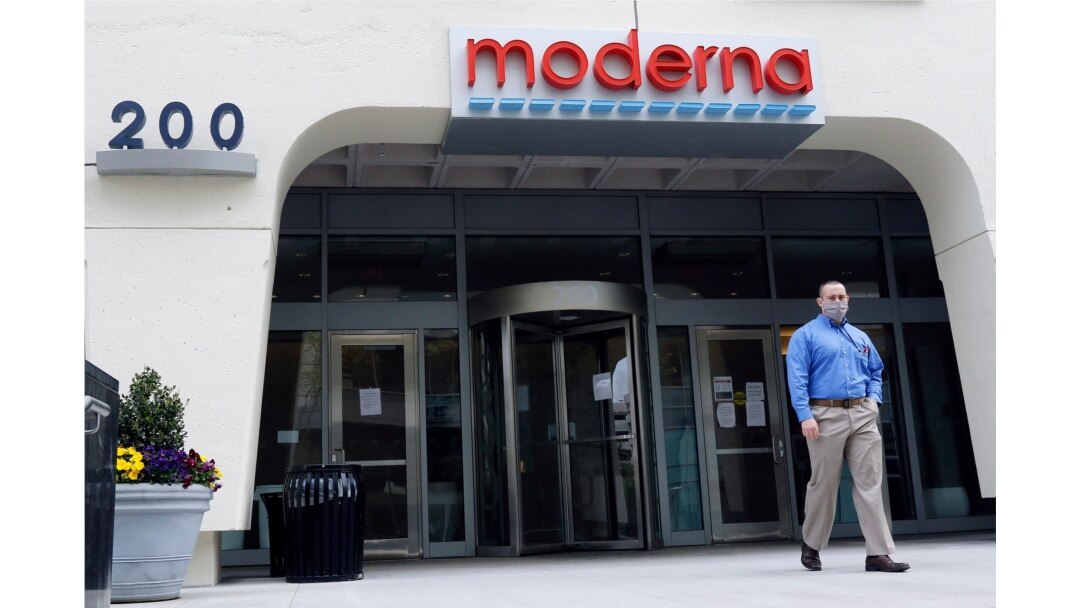 FILE - A man stands outside an entrance to a Moderna, Inc., building in Cambridge, Mass., May 18, 2020. Moderna entered the first phase of a three-step clinical trial process for a COVID-19 vaccine in mid-March.