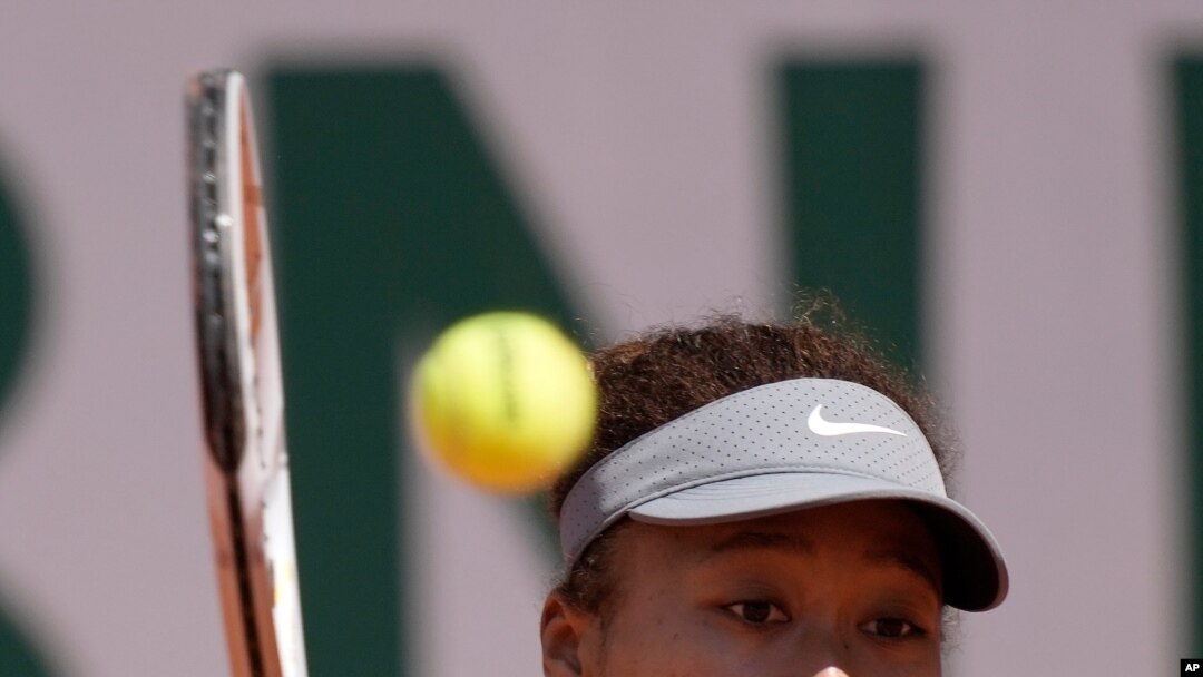 Japan's Naomi Osaka returns the ball to Romania's Patricia Maria Tig during their first round match of the French open tennis tournament at the Roland Garros stadium, May 30, 2021 in Paris.