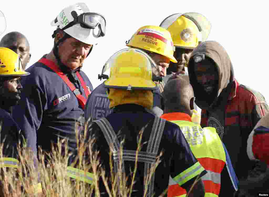 A suspected illegal miner talks to officials after being rescued from an abandoned gold shaft in Benoni, east of Johannesburg, South Africa, Feb. 16, 2014.