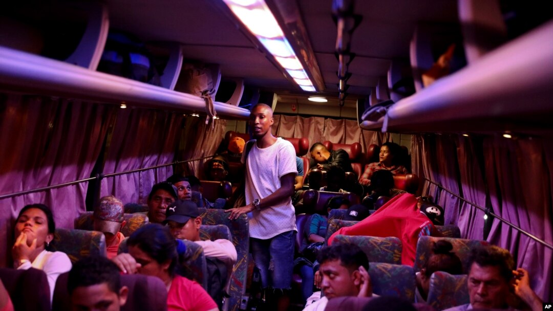FILE - People wait on board a bus, on their way to the U.S. border, in Tegucigalpa, Honduras, Aug. 20, 2019.