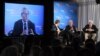 Former Washington Post reporter Bob Woodward, is seen on the monitor as moderator Charlie Rose, left, Woodward and Bernstein speak during an event to commemorate the 40th anniversary of Watergate, June 11, 2012.