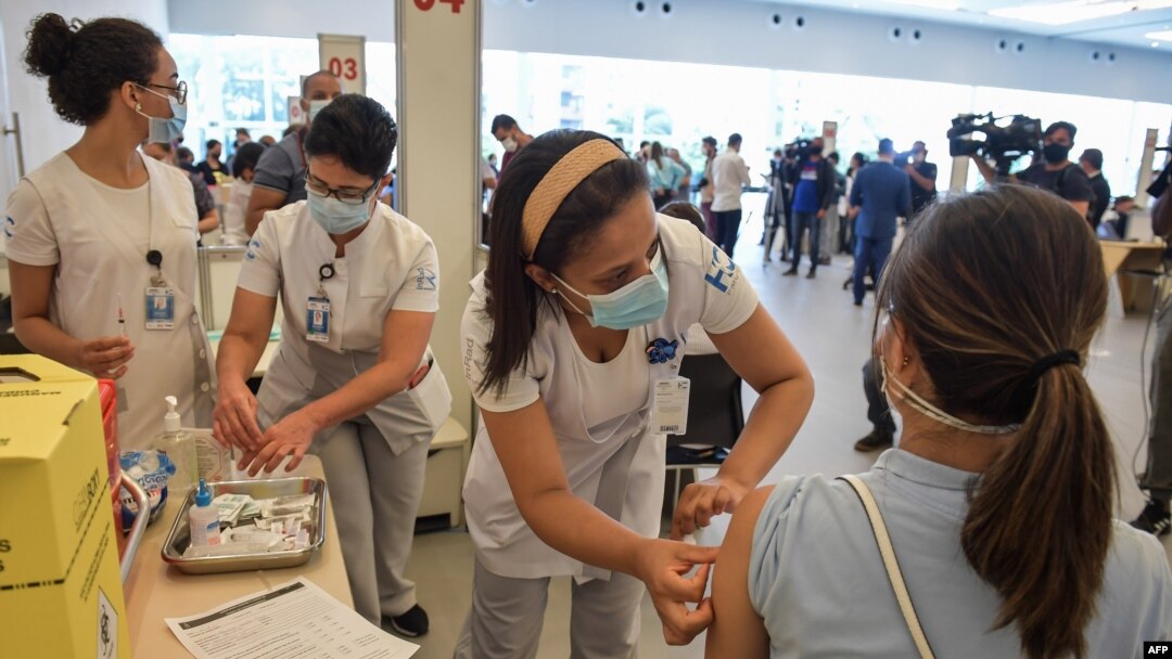 A health worker is inoculated with a COVID vaccine at the Clinicas Hospital in Sao Paulo, Brazil, Jan. 18, 2021.