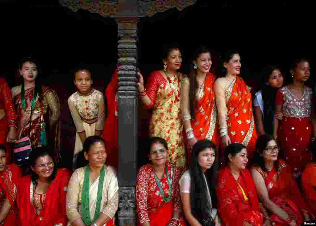 People watch as women sing and dance at the premises of Pashupatinath Temple during the Teej festival in Kathmandu, Nepal.