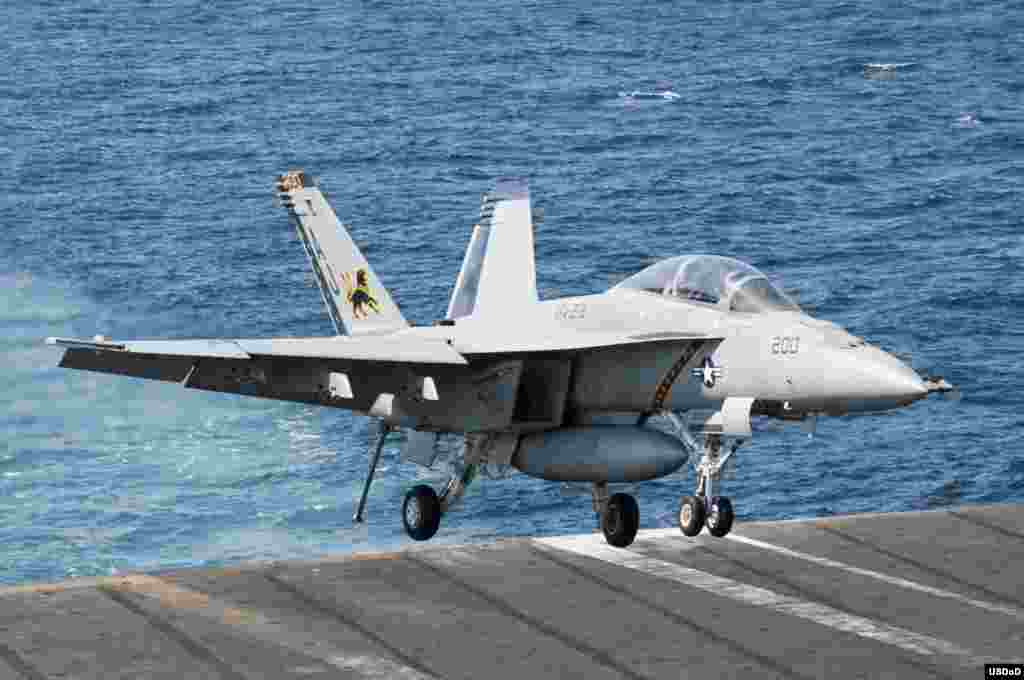 An F/A-18F Super Hornet attached to the Fighting Black Lions of Strike Fighter Squadron (VFA) 213 lands aboard the aircraft carrier USS George H.W. Bush (CVN 77) after conducting strike missions against ISIL targets. George H.W. Bush is supporting maritime security operations and theater security cooperation efforts in the U.S. 5th Fleet area of responsibility, Arabian Gulf, Sept. 23, 2014. (U.S. Navy photo by Mass Communication Specialist 3rd Class Brian Stephens/Released)