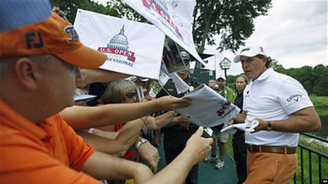 Phil Mickelson signs autographs after a practice round for the U.S. Open Championship golf tournament at Congressional Country Club in Bethesda, Maryland, June 14, 2011