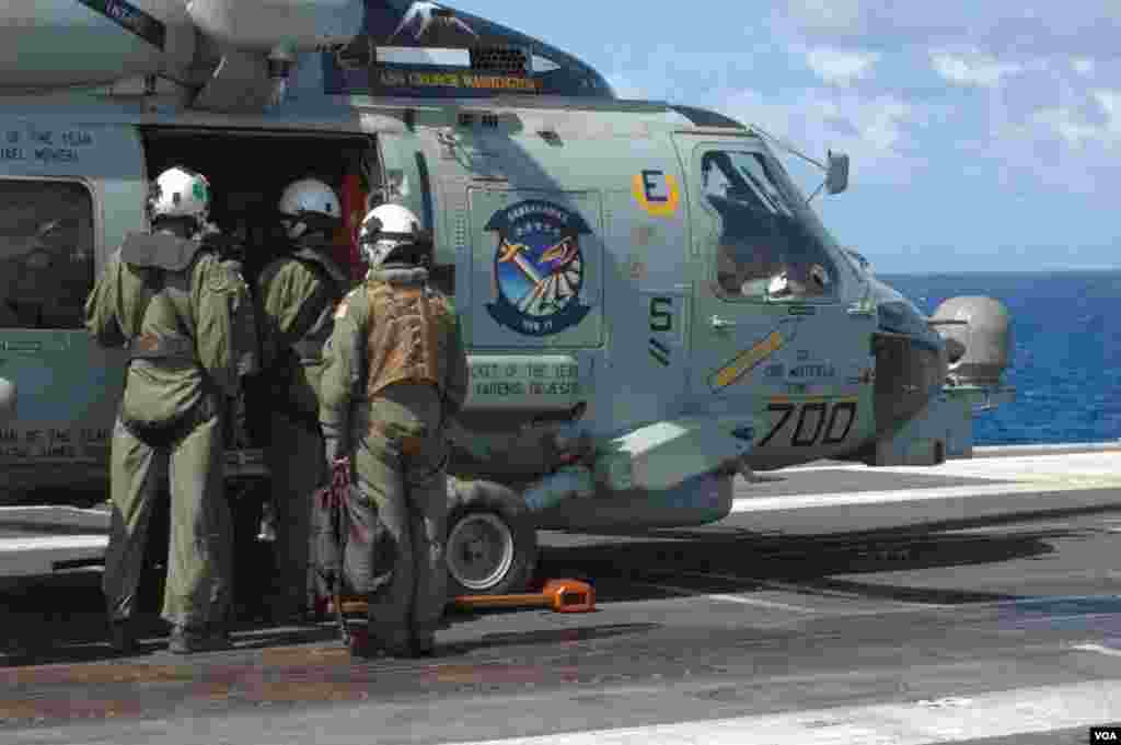 A change of crew on the deck of the USS George Washington for the MH-60 Sea Hawk helicopter on which a VOA crew rode, Nov. 19, 2013. (Steve Herman/VOA)