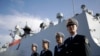 FILE - In this Dec. 7, 2016, photo, Chinese Navy officials stand in front of the ship Daqing, in San Diego.