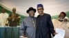 Nigeria's President Goodluck Jonathan, center-left, and President-elect Gen. Muhammadu Buhari, center-right, hug and shake hands after signing a renewal of their pledge to hold peaceful "free, fair, and credible" elections, at a hotel in the capital. 