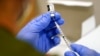 FILE - A health care worker fills a syringe with the Pfizer COVID-19 vaccine at Jackson Memorial Hospital, in Miami, Oct. 5, 2021. 