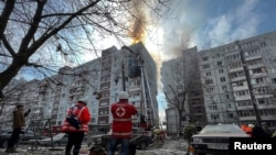 Парамедики та рятувальники біля зруйнованого внаслідок російського обстрілу житлового будинку, Запоріжжя. Україна. 22 березня , 2023. REUTERS/Sergiy Chalyi