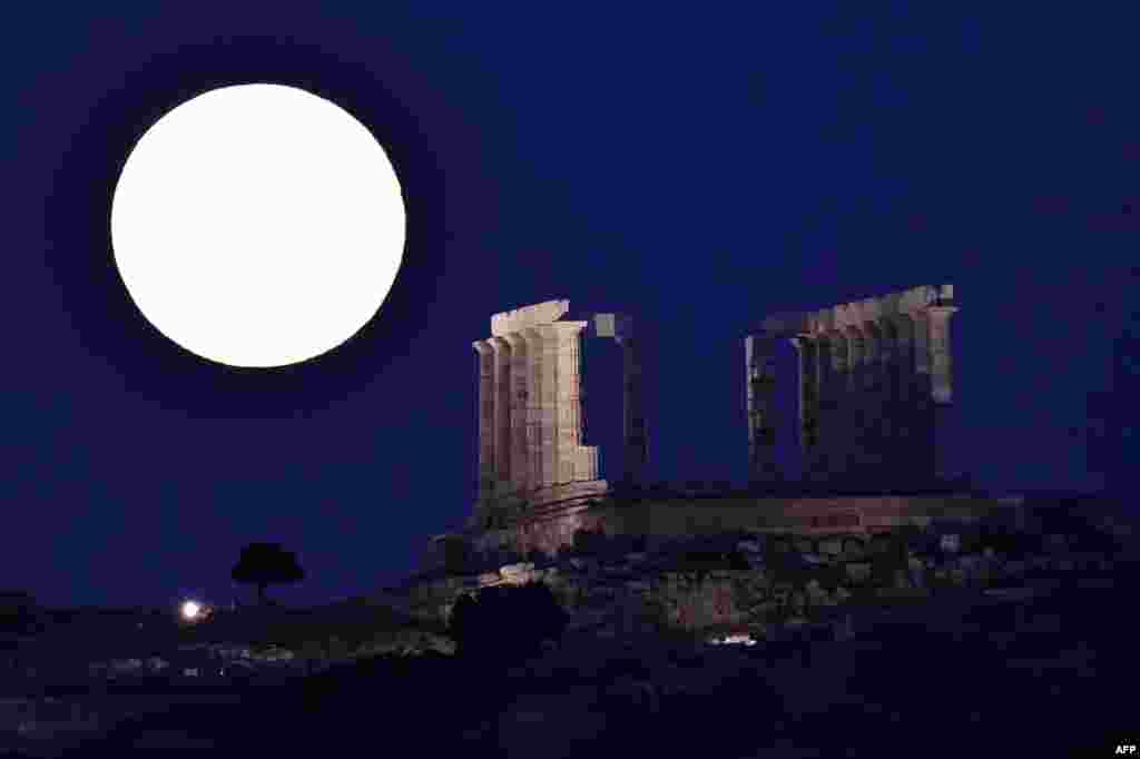 The full moon rises by the ancient temple of Poseidon (Neptun) at cape Sounio, some 65 km southeast of Athens, Greece, July 9, 2017.