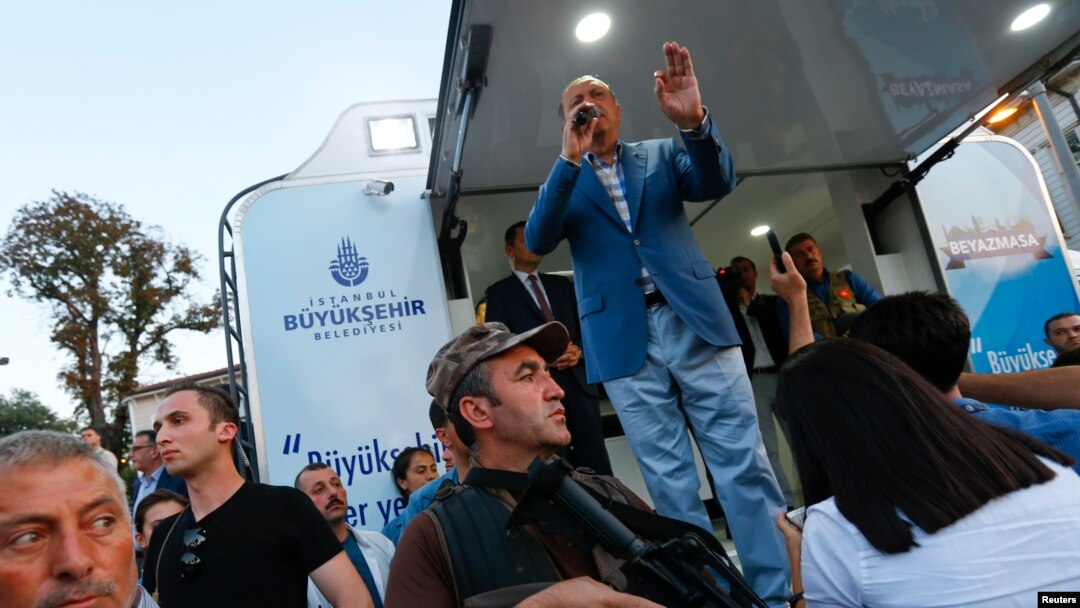 Turkish President Recep Tayyip Erdogan makes a speech protected by bodyguards in Istanbul, July 16, 2016. 