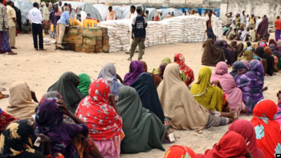 Internally displaced Somali women queue to receive food-aid rations at a distribution center
