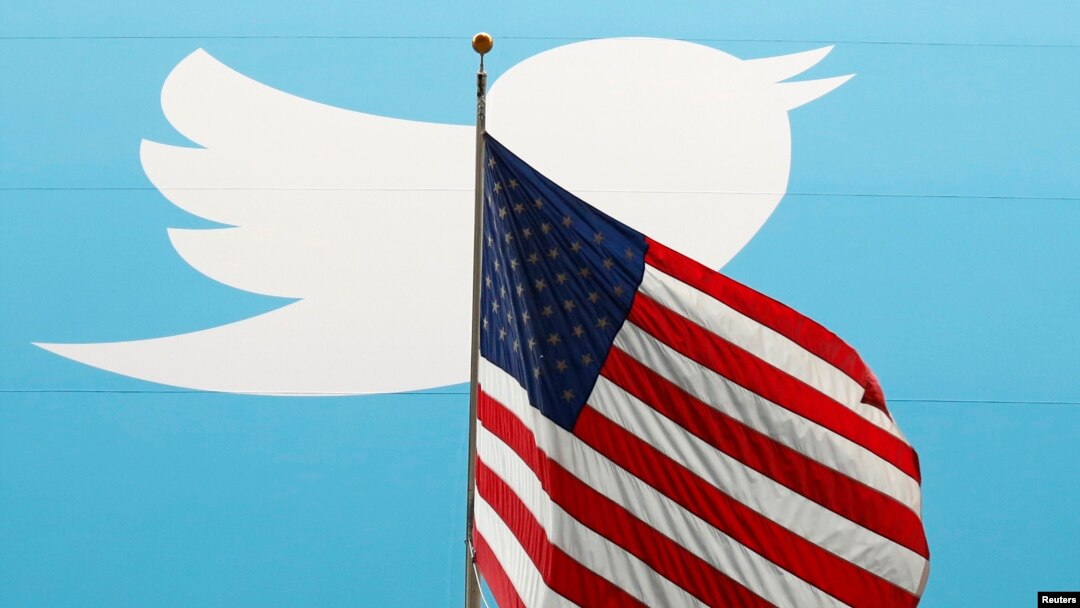 FILE - The Twitter Inc. logo is shown with the U.S. flag during the company's IPO on the floor of the New York Stock Exchange in New York, Nov. 7, 2013. 