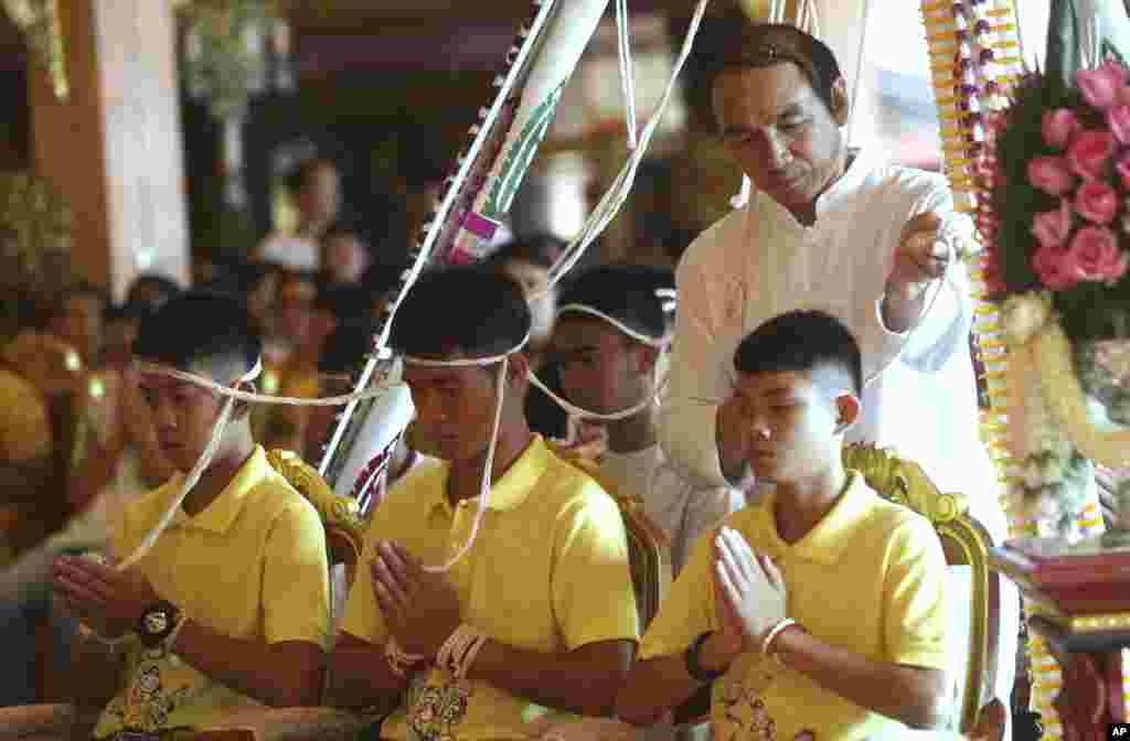 Coach Ekkapol Janthawong, center, and members of the rescued soccer team attend a Buddhist ceremony that is believed by some to extend the lives of those participating, as well as ridding them of danger and misfortune, in the Mae Sai district, Chiang Rai province, Thailand.