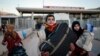Members of a Syrian family carry their belongings after they crossed into Turkey at the Cilvegozu border gate with Syria, near Hatay, southeastern Turkey, Dec, 18, 2016.