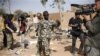 Malian soldier gestures at journalists to leave area of a French air strike in Konna, 430 miles north of Bamako, Jan. 26, 2013.