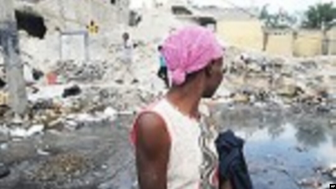 A Haitian woman waiting for a taxi in Port-au-Prince looks at earthquake damage on January 9, 2012. According to the UN some 50 percent of the rubble left by the January 12, 2010 earthquake still litters the Haitian capital.