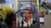 Candles burn in front of a portrait of Nelson Mandela outside of the Mediclinic Heart hospital in Pretoria on July 6, 2013.