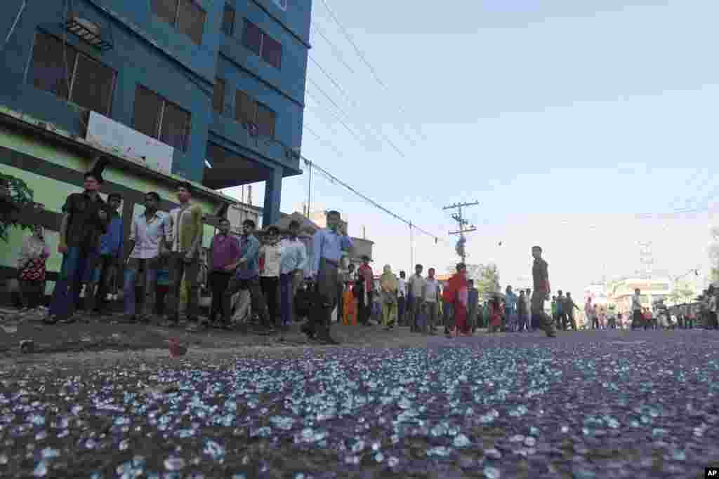 Garment workers walk out from a factory as other workers clash with police in Ashulia on the outskirts of Dhaka, Bangladesh, Nov. 12, 2013.