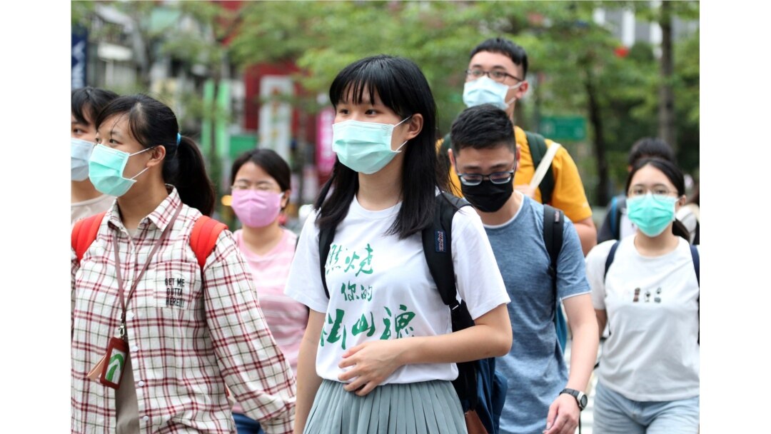 People wearing face masks to protect against the spread of the coronavirus travel around Taipei, Taiwan, May 18, 2020.
