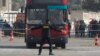 A policeman stands guard at the scene of a bomb blast that damaged a bus near the Al-Azhar University campus in Cairo's Nasr City district, Egypt, Dec. 26, 2013.