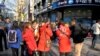 Foreign tourists consult with South Korean tour guides wearing red jackets in a crowded shopping district in Seoul on Apr. 9, 2013.