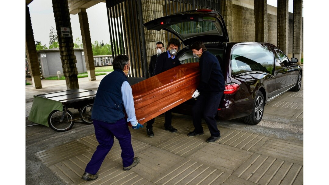 Undertakers wearing protection masks to protect from the coronavirus carry a coffin to a burial at San Jose cemetery in Pamplona, in Pamplona, northern Spain, April 13, 2020.