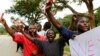 Roman Catholic priest Frank Bwalya (in red) and supporters hold red cards to display their displeasure with the government as they attend a rally in front of the National Assembly, in Lusaka, Zambia, March 22, 2011.