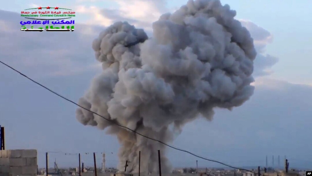 This image taken from video provided by the Syrian activist-based media group Syrian Revolutionary Command Council in Hama, which has-been verified and is consistent with other AP reporting, shows smoke rising after a Russian airstrike hit buildings in th
