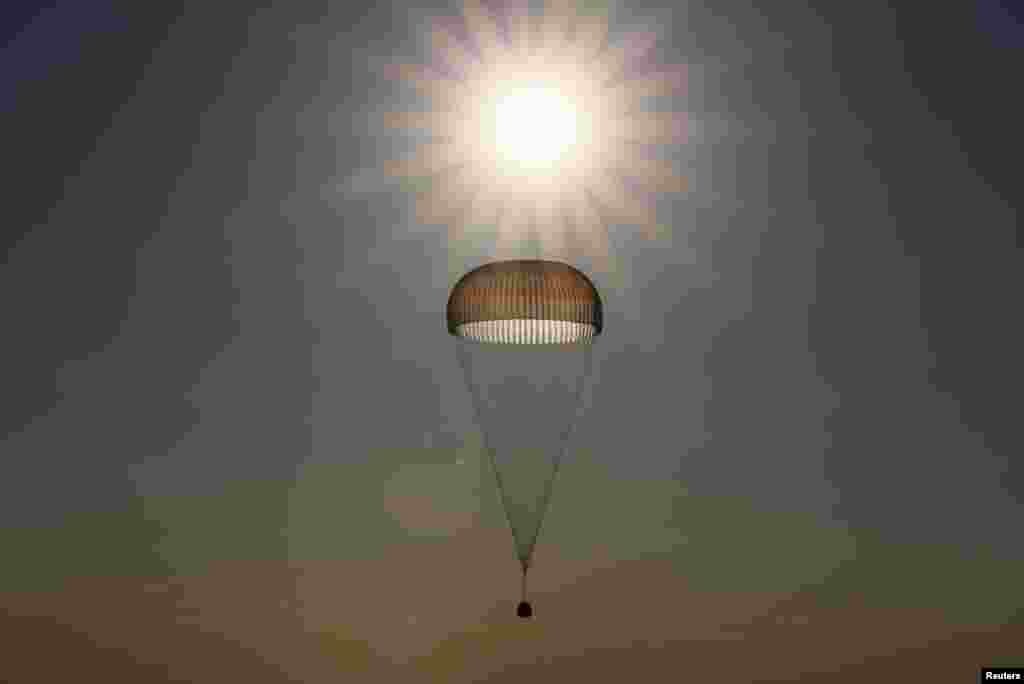 The Soyuz MS-03 capsule, carrying the International Space Station (ISS) crew of Oleg Novitskiy of Russia and Thomas Pesquet of France, is silhouetted against the sun as it descends beneath a parachute just before landing in a remote area outside Dzhezkazgan, Kazakhstan.