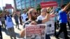 Activists, one holding today's copy of the Cumhuriyet newspaper, march to a court in Istanbul, July 24, 2017, protesting against the trial of journalists and staff from the newspaper, accused of aiding terror organizations. 
