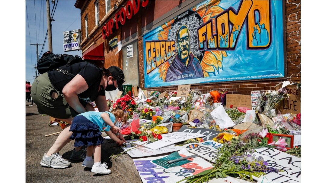 Jessica Knutson, and her daughter Abigail, 3, place flowers at a memorial to George Floyd, May 31, 2020, in Minneapolis.