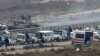 Forces loyal to Syria's President Bashar al-Assad sit on a tank as a convoy bringing people out of eastern Aleppo turns back in the direction of the besieged rebel enclave, Syria Dec. 16, 2016.