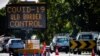 A COVID-19 sign marks a vehicle checkpoint on the Pacific Highway on the Queensland - New South Wales border in Brisbane, Australia, on April 15, 2020. 