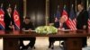 U.S. President Donald Trump and North Korea's leader Kim Jong Un sign documents that acknowledge the progress of the talks and pledge to keep momentum going, after their summit at the Capella Hotel on Sentosa island in Singapore, June 12, 2018. 