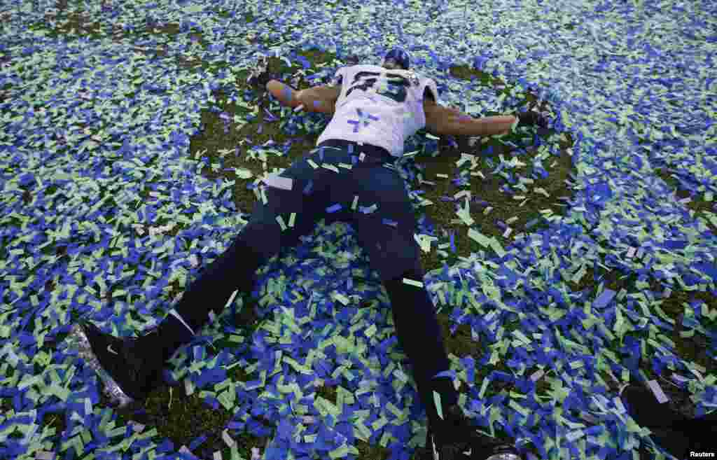 Seattle Seahawks Malcom Smith makes an 'angel' in the confetti after his team defeated the Denver Broncos in the Super Bowl XLVIII football game in East Rutherford, New Jersey, Feb. 2, 2014.