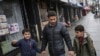 FILE - Sadek Ahmed walks with his sons Adel, 9, right, and Mutaz, 7, in New York, March 21, 2019. Their mother is stuck in Yemen with her two younger sons, the boys’ brothers. Their situation is representative of the toll the travel ban has on families.