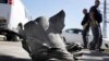 Israeli explosives experts stand by a rocket fired from the northern Gaza Strip that landed near the coastal city of Ashkelon, Feb. 26, 2013.