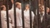 FILE - A Nov. 2013 image made from video provided by Egypt's Interior Ministry shows ousted President Mohammed Morsi (R), speaking from the defendant's cage during a trial hearing in Cairo, Egypt.