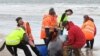 This handout photo taken by Brodie Weeding from The Advocate, Sept. 22, 2020, shows rescuers working to save a pod of whales stranded on a beach in Macquarie Harbor on the rugged west coast of Tasmania, Australia.