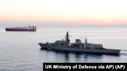 英国皇家海军护卫舰“蒙特罗斯”号2019年7月11日在霍尔木兹海峡为一艘油轮护航。
