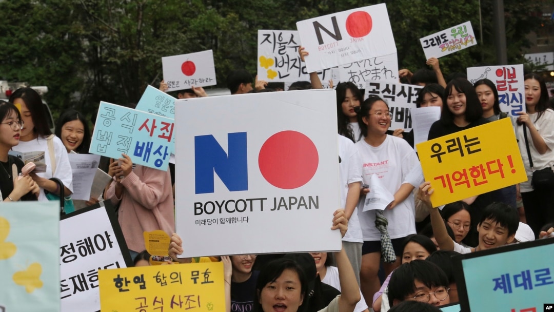 South Korean protesters hold up cards calling for a boycott of Japanese products during a rally demanding full compensation and an apology for wartime sex slaves from Japan in front of the Japanese Embassy in Seoul, South Korea, July 31, 2019.