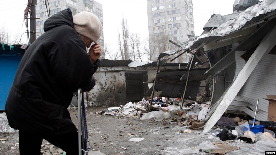 A woman reacts as she stands at a market that, according to locals, was recently damaged by shelling, in Donetsk, eastern Ukraine, Jan. 19, 2015. 