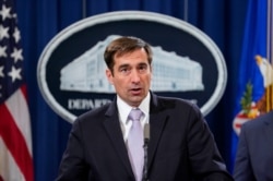 FILE _ Assistant Attorney General for National Security John C. Demers, speaks during a news conference to announce a criminal law enforcement action involving China, at the Department of Justice in Washington, Nov. 1, 2018.