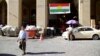 FILE - A man walks past a campaign slogan printed on a Kurdish flag urging people to vote "yes" in the upcoming poll on independence from Iraq, in Irbil, Iraq, Aug. 24, 2017.