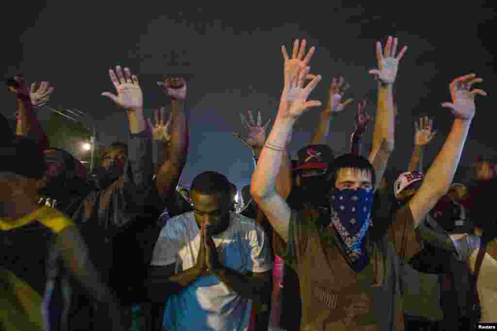 Namoyishchilar favqulodda holat e'lon qilinganiga qaramay, ko'chalarni tark etmayapti, Ferguson, 17-avgust, 2014-yil.