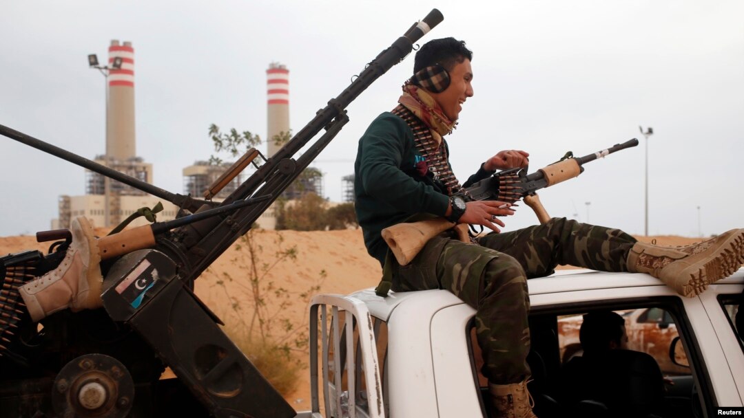 A pro-Libyan government fighter from Misrata sits on top of a vehicle near Sirte, March 16, 2015. 